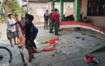 Satgas TMMD dan Warga Bergotong Royong Pasang Umbul-Umbul Sambut HUT ke-81 Kemerdekaan RI