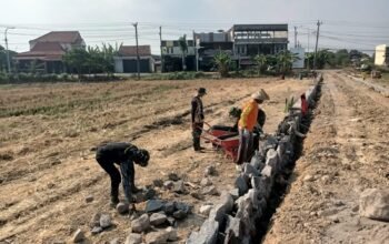 Anggota Satgas Tmmd Kodim 0726/Sukoharjo Menyusun Rapi Batu Pondasi Di Lokasi Pembangunan Jalan Desa Parang Joro